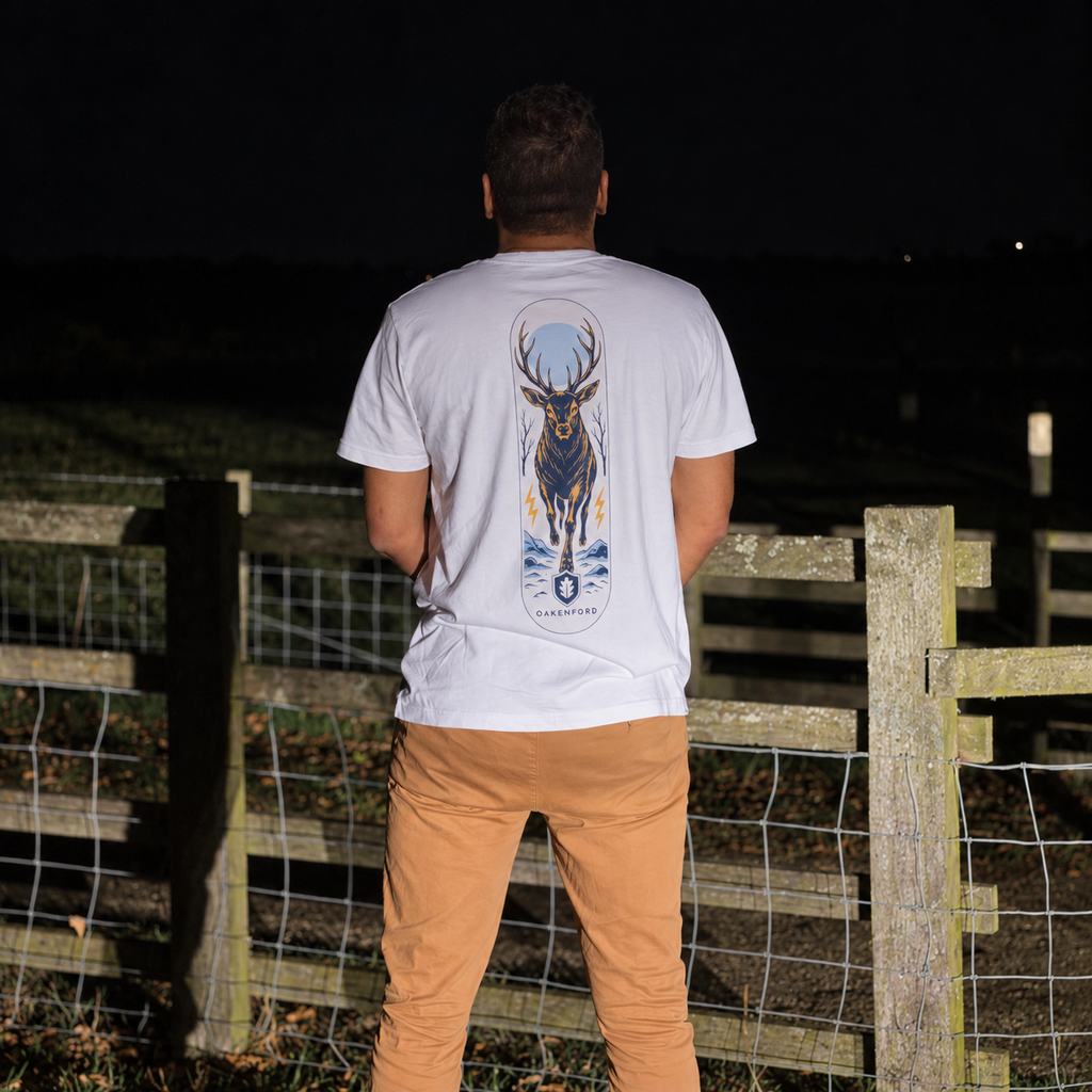 White Night Stag T-shirt worn outdoors beside a wooden fence at night, back view