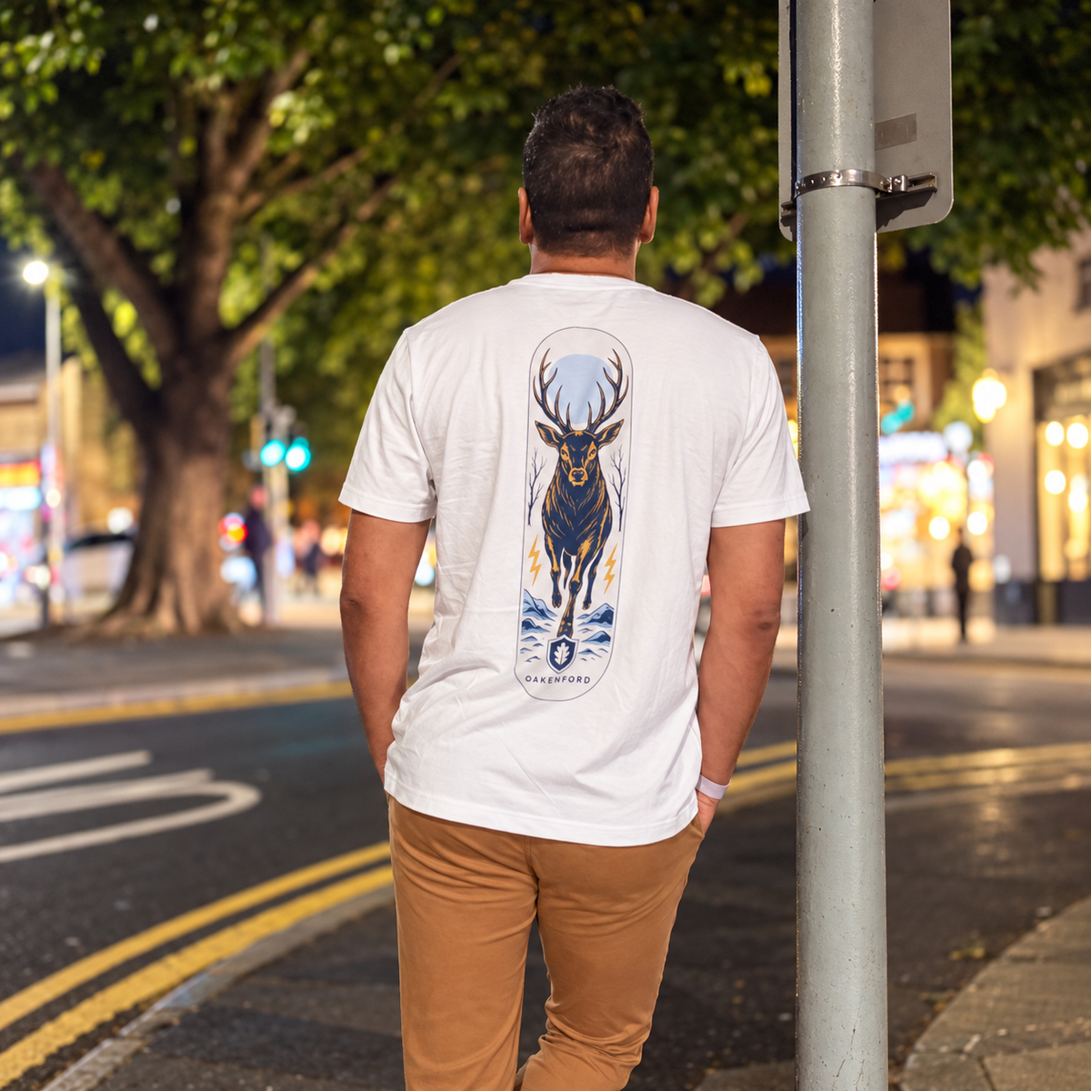 White Night Stag T-shirt worn on a city street at night, back view