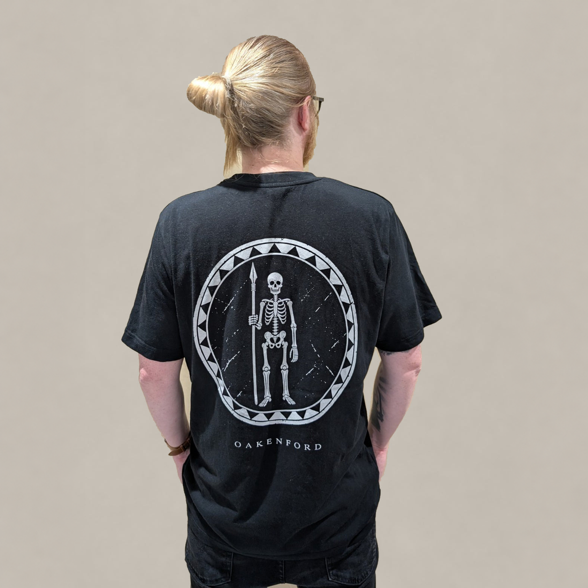 Model wearing the black Skeleton Shield T-shirt, rear view.