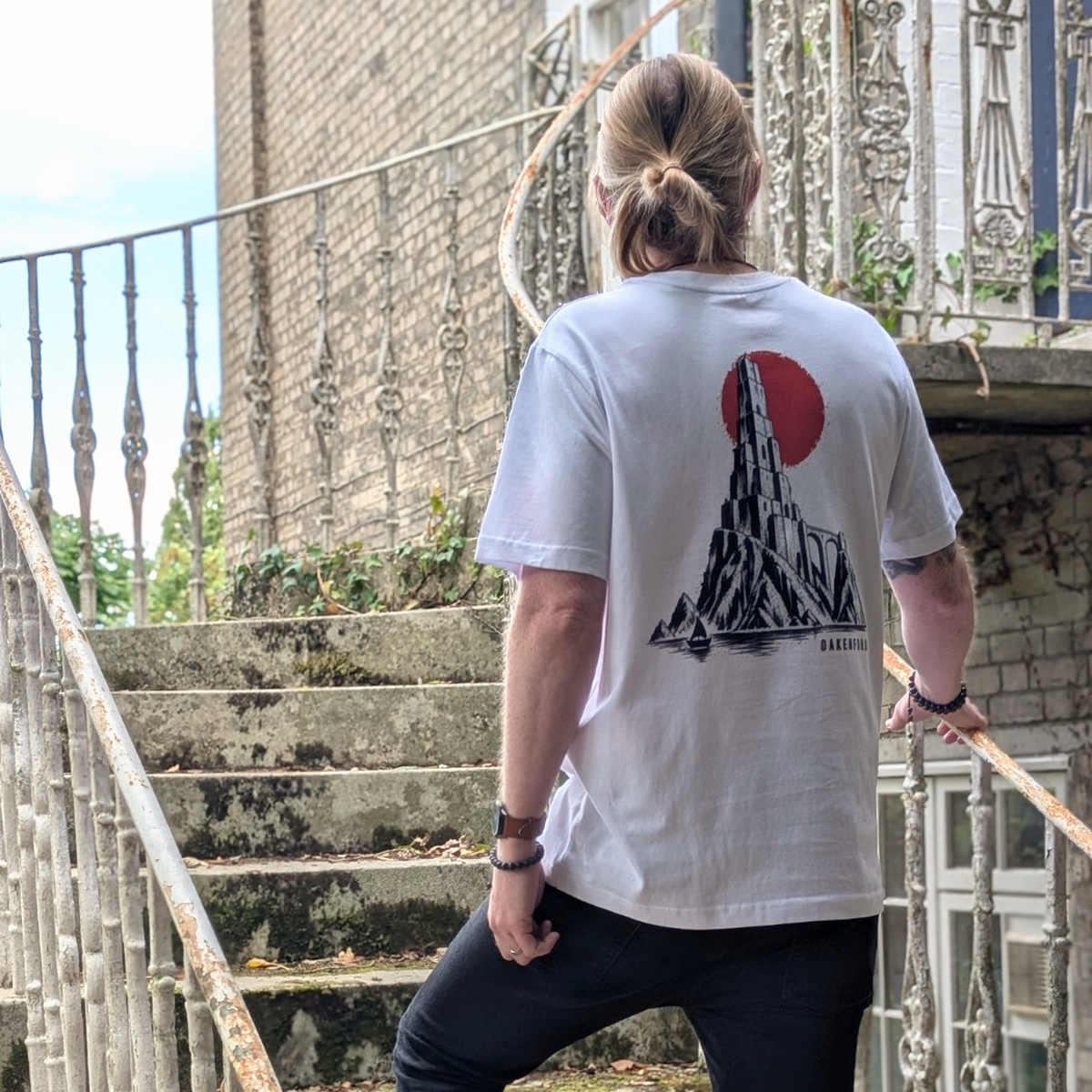 Model wearing the white The Sea Spire Oakenford T-shirt, showing the back print